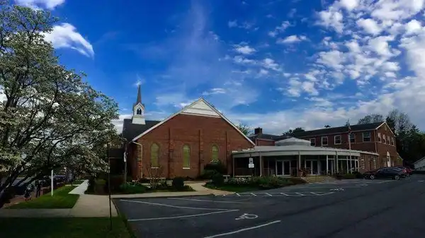 Prayer Tower's red brick church building and parking lot on a clear spring day