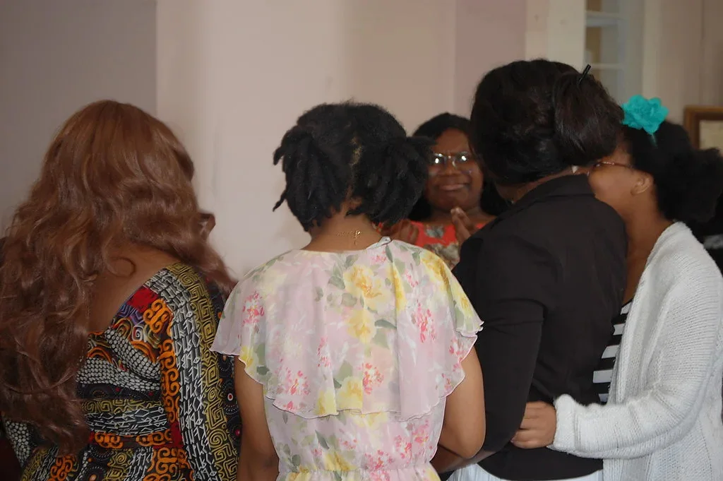 Women of Prayer Tower Church standing together in prayer, one with her hand on another's shoulder